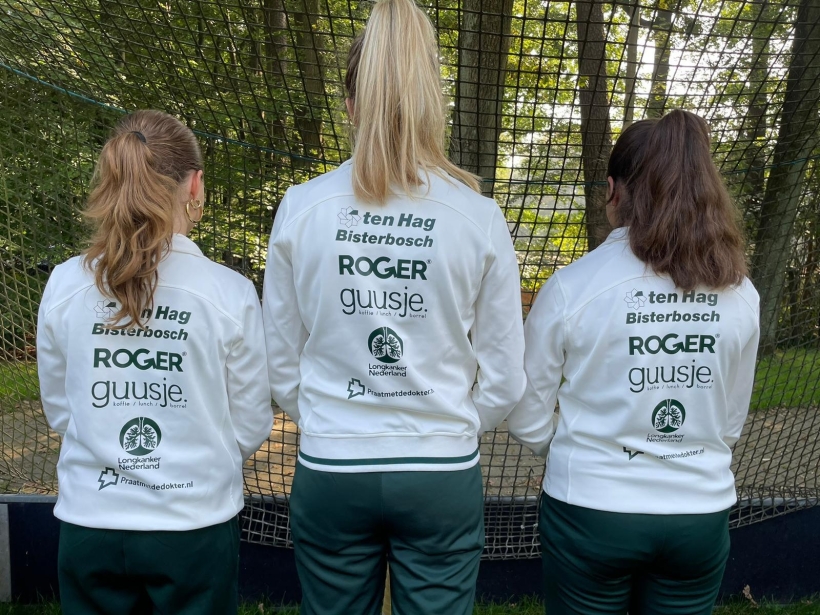 Achterzijde 3 hockeysters met logo op trainingspak